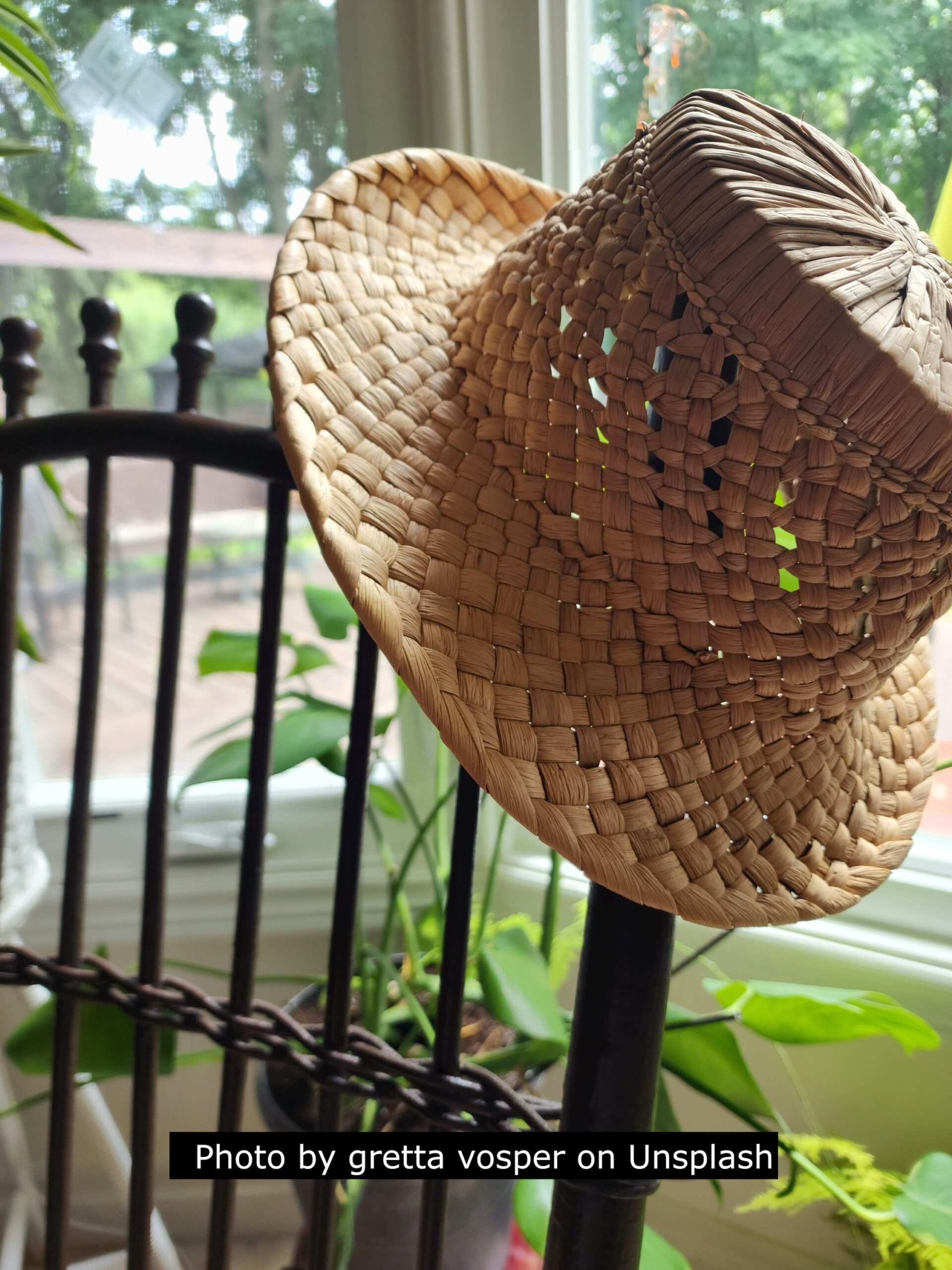 Straw hat hanging on garden chair